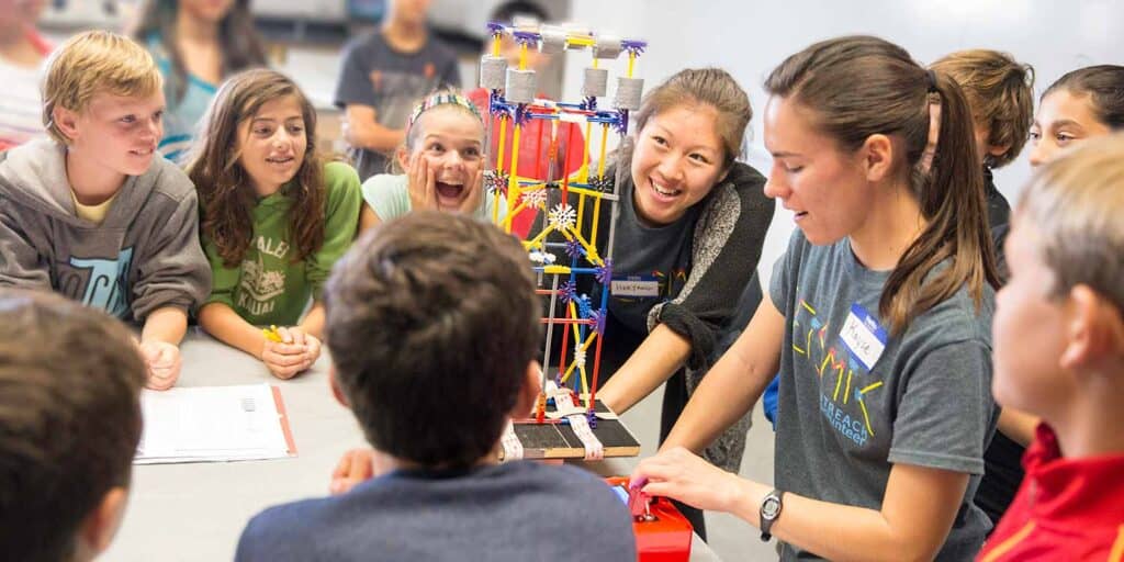 a teacher aide working with a group of smiling students