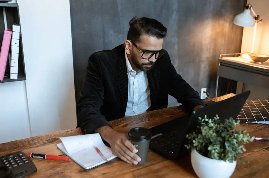 man writing a CV at computer
