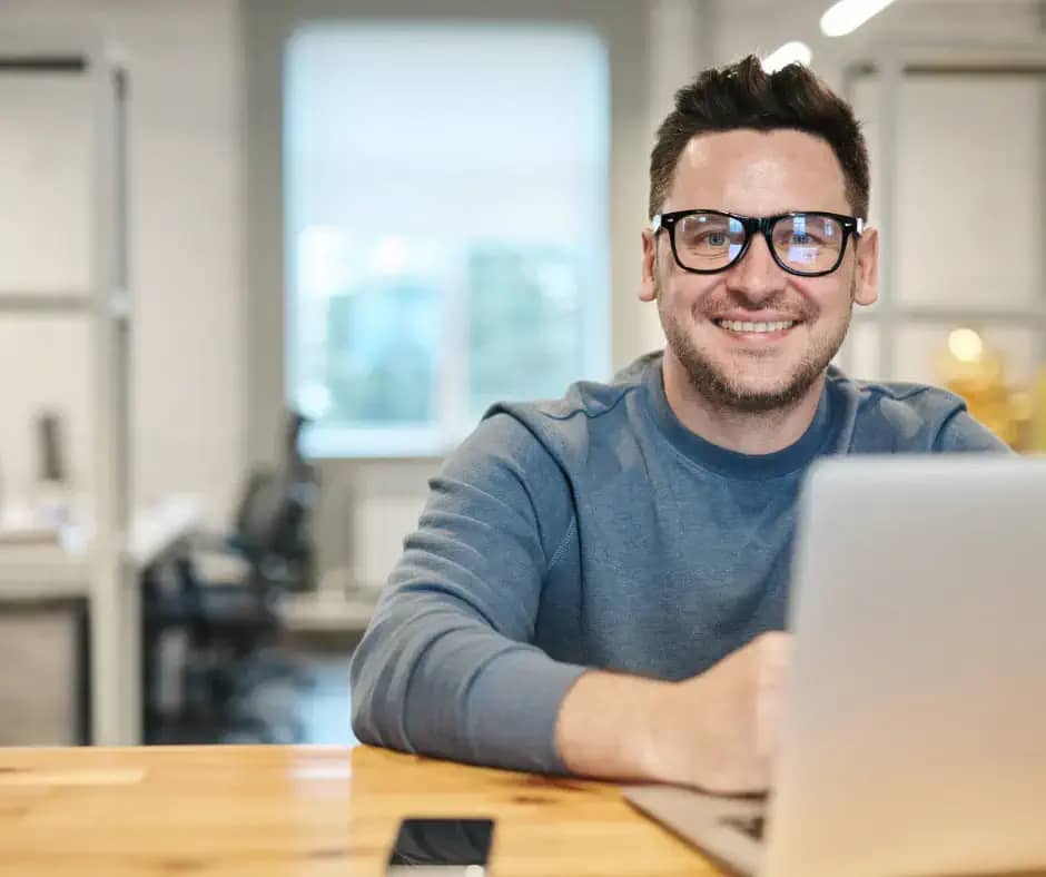 man smiling with laptop