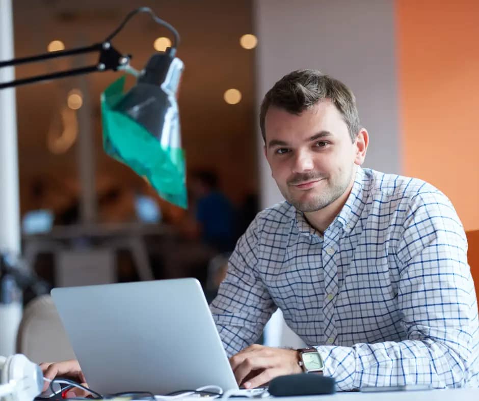 man working at laptop smiling