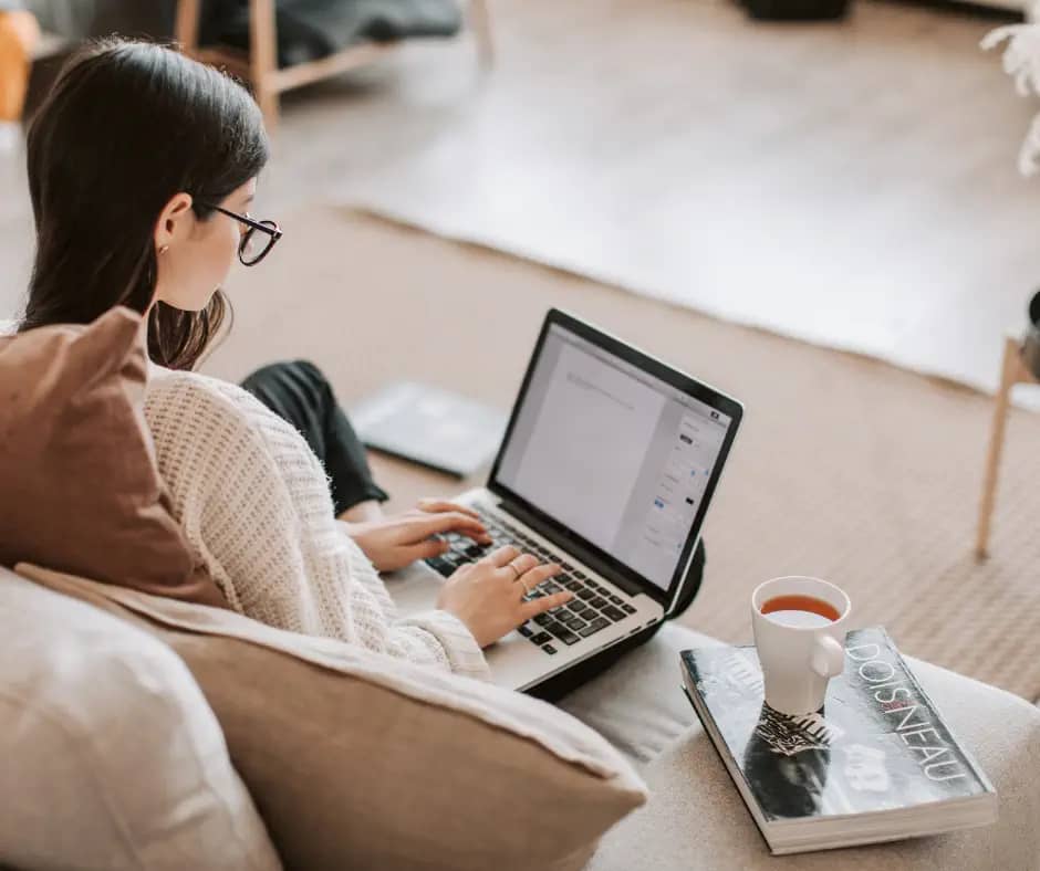 young woman using laptop on a couch